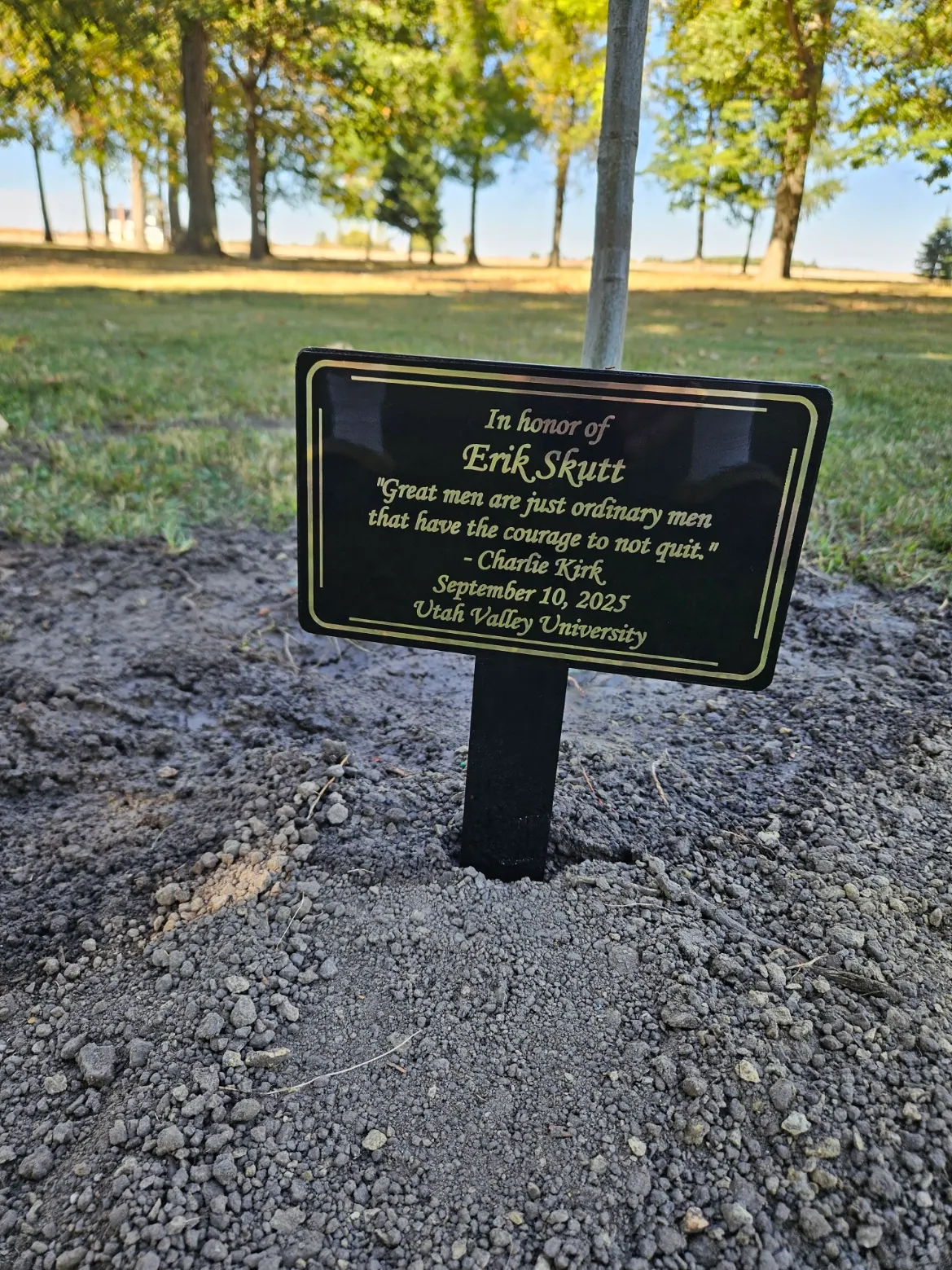 Memorial plaque reading: In honor of Erik Skutt. "Great men are just ordinary men that have the courage to not quit." — Charlie Kirk, September 10, 2025, Utah Valley University.
